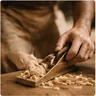 A carpenter shaping timber at the bench