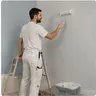 A decorator rolling paint onto a wall