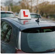 A driving-school car with a roof-mounted L plate